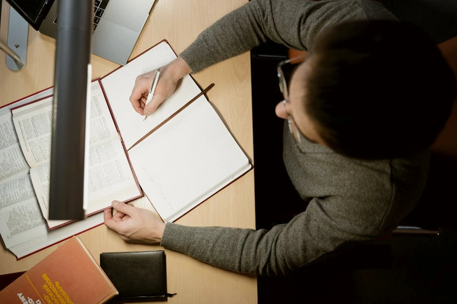 Usměvavá studentka s notebookem a barevnými poznámkami